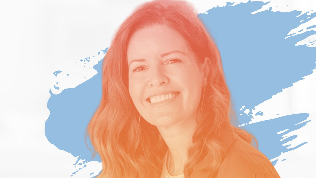 Smiling woman with long red hair in an olive jacket, for the BelleSkin article The Best Sunscreens for Melasma-Prone Skin Over 40