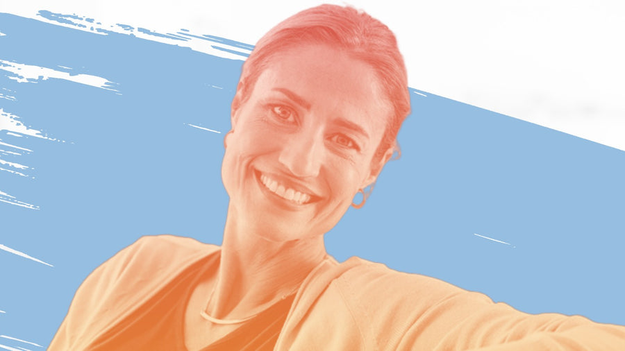Smiling woman with brown hair in a grey cardigan, for the BelleSkin article A 6-Step Dark Circle Eye Routine for Women Over 40, Morning and Night