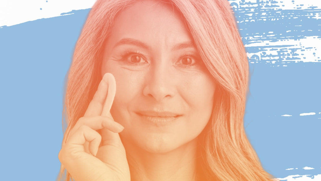 Woman with long grey hair touching her cheek, for the BelleSkin article Dark Spots on Deeper Skin Tones: What to Know Before You Buy